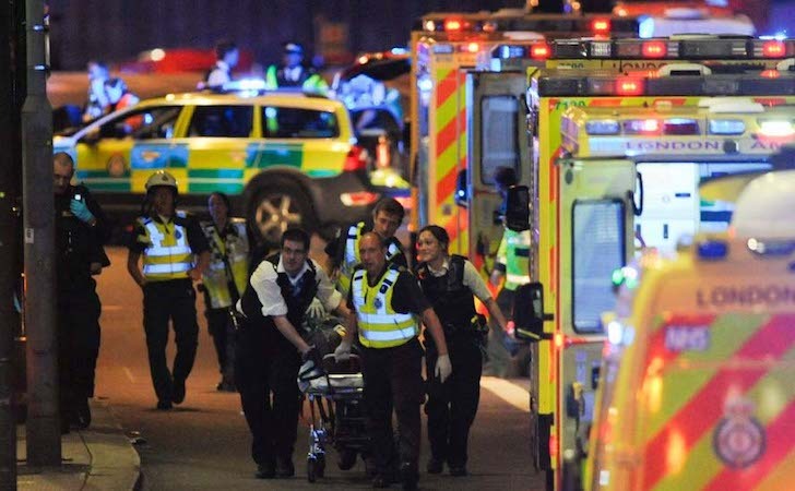 Ofiţeri de poliţie şi membri ai serviciilor de urgenţă îngrijesc o persoană rănită în timpul unui atac terorist pe Podul Londrei în 3 iunie 2017. (Daniel Sorabji/AFP/Getty Images)