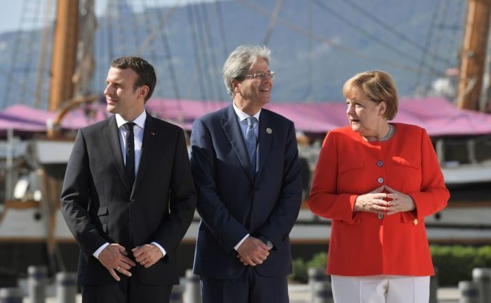Cancelarul german Angela Merkel (dr), preşedintele francez Emmanuel Macron (st) şi premierul italian Paolo Gentiloni (centru) participă la un summit în oraşul italian Triest, 12 iulie 2017.
