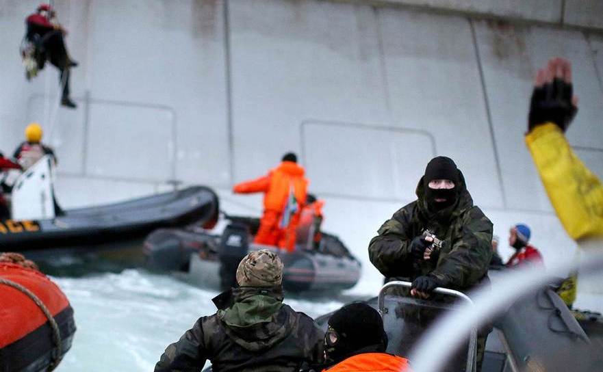 Activişti Greenpeace arestaţi sub ameninţarea armelor de către ofiţeri ai Pazei de Coastă a Rusiei după ce aceştia au încercat să escaladeze platforma petrolieră Prirazlomnaya Arctic, care aparţine gigantului rus Gazprom, în largul coastei nord-estice a Rusiei, Marea Pechora, 18 septembrie 2013. (Denis Siniakov/AFP/Getty Images)