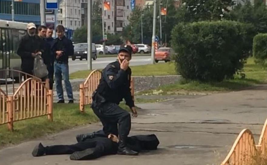 Un ofiţer rus de poliţie stă deasupra unui bărbat implicat în înjunghierea mai multor persoane în oraşul Surgut din Siberia. (Captură YouTube)