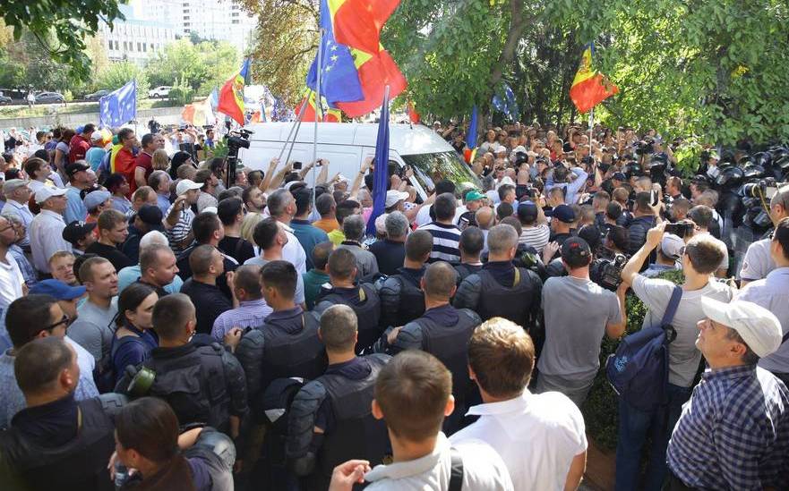 Microbuzul înconjurat de protestatari şi poliţişti la manifestaţia din faţa postului TV Moldova 1 din R. Moldova 17.09.2017