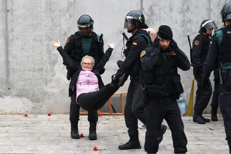 O femeie este luată pe sus de forţele de ordine spaniole în timpul unei ciocniri cu manifestanţii catalani pro-independenţă, 1 octombrie 2017.