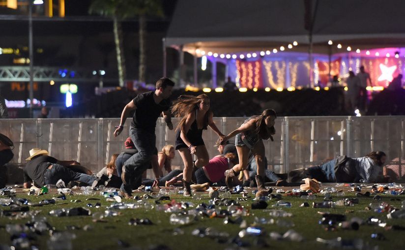 Persoane caută un loc sigur după ce au fost auzite focuri de armă la un festival de muzică din Las Vegas, 1 octombrie 2017. (David Becker/Getty Images)