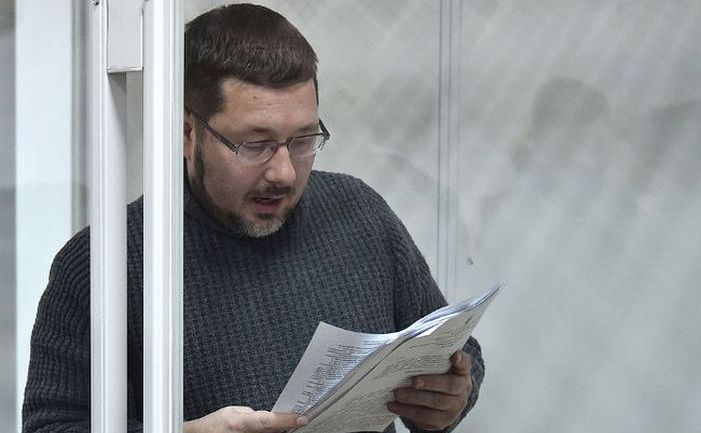 Stanislav Iezhov citeşte documente într-o cabină de sticlă la începutul audierii sale într-un tribunal din Kiev, 22 decembrie 2017. Iezhov este acuzat ca este un spion rus. (Genia Savilov/AFP/Getty Images)