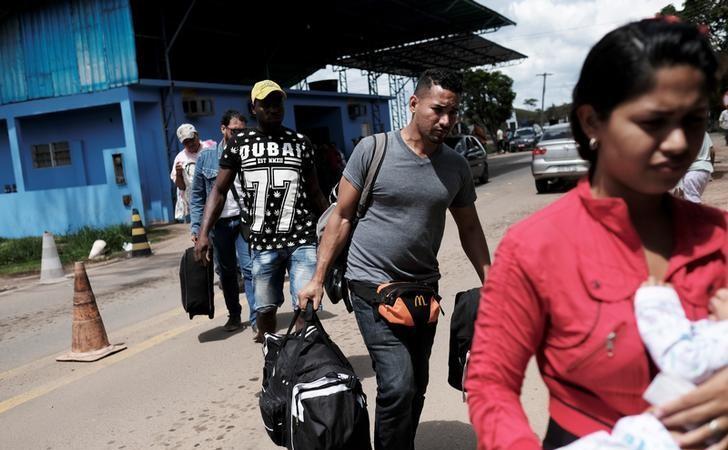 Imigranţi venezueleni îşi prezintă actele de identitate la punctul de frontietă Pacaraima, statul brazilian Roraima, 16 noiembrir 2017.