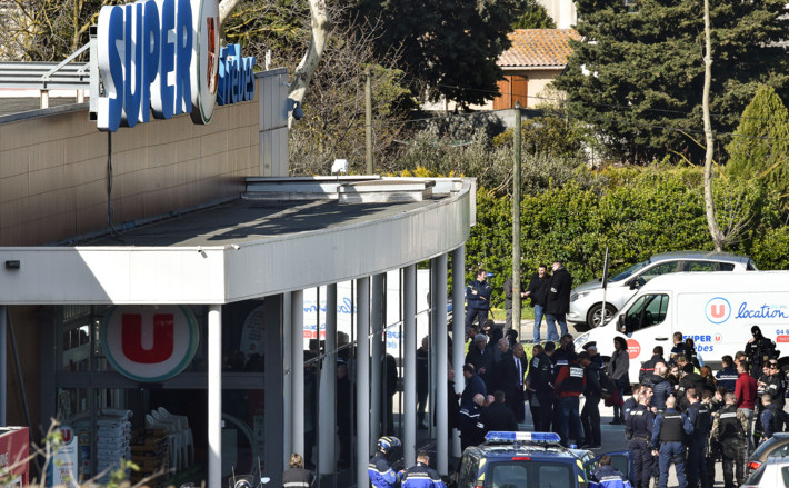 Forţe  de ordine se adună în faţa unui supermarket în Trebes, Franţa. Un  bărbat a luat mai mulţi ostatici înainte să fie ucis de poliţie în 23  martie 2018.
