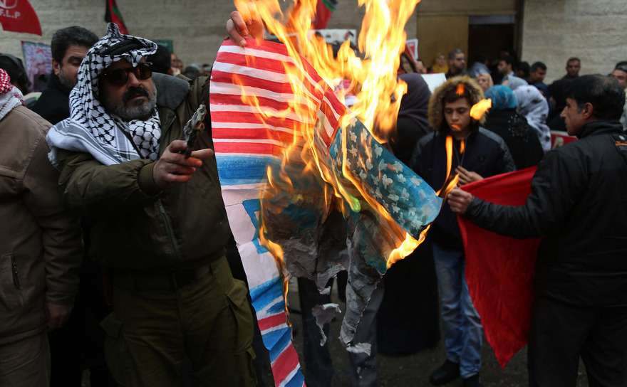 Manifestanţi palestinieni ard postere cu Donald Trump şi steaguri americane şi israeliene în timpul unui protest în Fâşia Gaza împotriva mutării ambasadei SUA din Tel Aviv în Ierusalim, 1 ianuarie 2018. Noi proteste, planificate pentru următoarele şase săptămâni, au început în 30 martie 2018 la graniţa dintre Gaza şi Israel. (Majdi Fathi/NurPhoto/Getty Images)