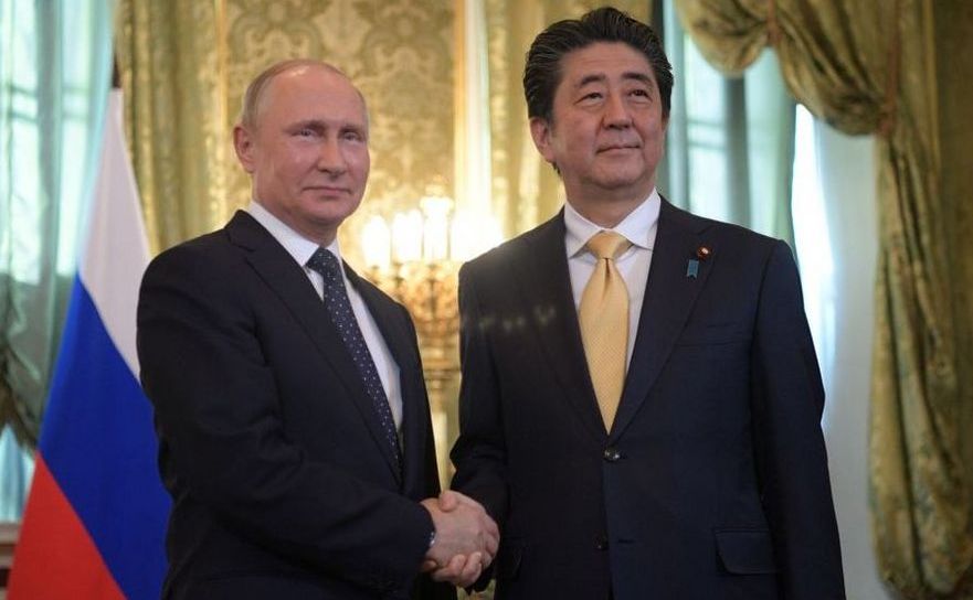 Preşedintele rus Vladimir Putin (st) dă mâna cu premierul nipon Shinzo Abe în timpul unei întâlniri la Moscova, Rusia, 26 mai 2018.