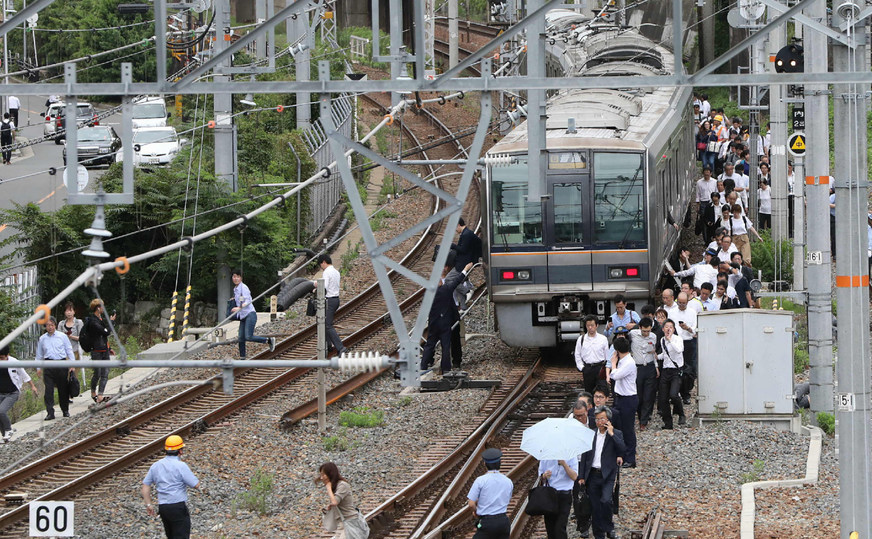 Călătorii unui tren merg de-a lungul şinelor după un cutremur în Osaka, Japonia, 18 iunie 2018.