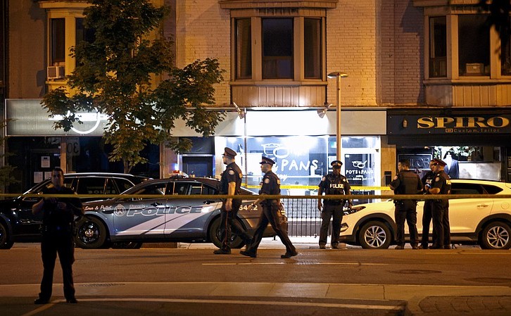 Ofiţeri de poliţie cercetează scena unui atac armat în cartierul grecesc din Toronto, Canada, 22 iulie 2018.