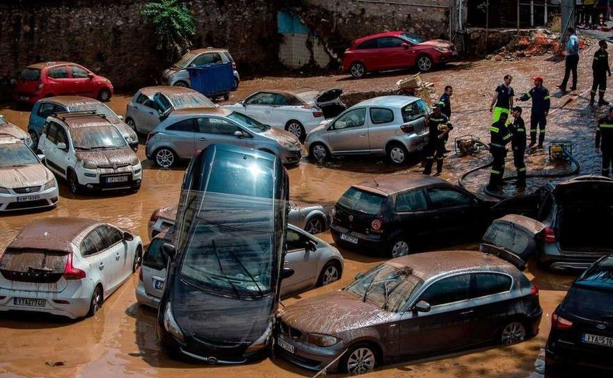 Membri ai serviciilor de urgenţă examinează o parcare auto pentru a se asigura că nu există oameni blocaţi în automobile după inundaţiile care au lovit Atena în 27 iulie 2018.