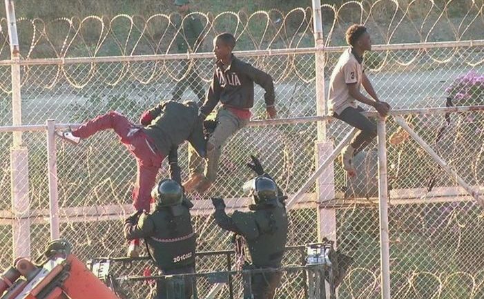 Imigranţi se caţără pe gardul de frontieră ce separă Maroc de enclava spaniolă Ceuta, 26 iulie 2018.