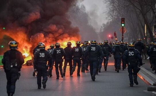 Un grup de poliţişti se îndreaptă spre o baricadă încendiată în Paris, 5 ianuarie 2019, în timpul unui protest al “vestelor galbene” (Eric Feferberg/AFP/Getty Images)