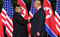 Preşedintele american Donald Trump (dr) dă mâna cu dictatorul nord-coreean Kim Jong-un la începerea summitului lor din Singapore, 12 iunie 2018 (Saul Loeb/AFP/Getty Images)