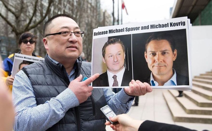 Louis  Huang, din grupul “Libertate şi Democraţie pentru China” din Vancouver,  afişează fotografii cu cetăţenii canadieni Michael Spavor şi Michael  Kovrig, acuzaţi în China de spionaj