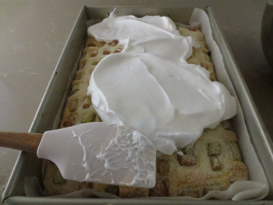 Prăjitura se scoate din cuptor şi se întinde spuma bătută pe deasupra. (Maria Matyiku / Epoch Times)