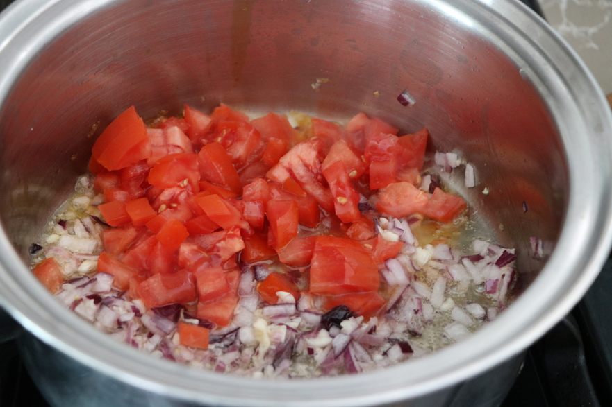 Se prepară ceapa tocată mărunt şi usturoiul apoi se adaugă roşiile tăiate (Maria Matyiku / Epoch Times)