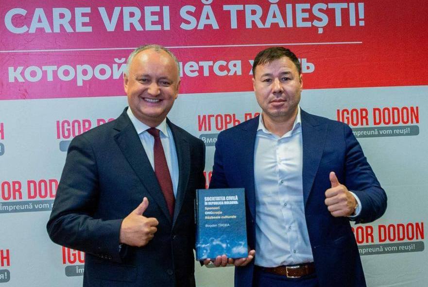 Bogdan Ţîrdea şi Igor Dodon tinând în mâni cartea: Societatea civilă a Republicii Moldova: Sponsori. ONG-craţie. Războaie culturale