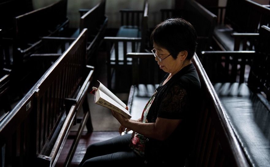 Femeie creştină din China, citind Biblia în biserica Gloria Creştină, Wuhan, 2018