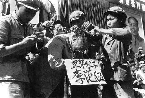 Umilirea intelectualilor în public în timpul Revoluţiei Culturale, 1966. Cuvintele de pe panou susţin că victima este membru al unei "clase sociale negre" (Public Domain)