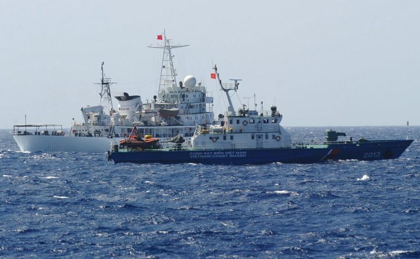 O navă de coastă (în spate) navighează lângă o navă vietnameză de pază într-o zonă disputată de China în Marea Chinei de Sud 