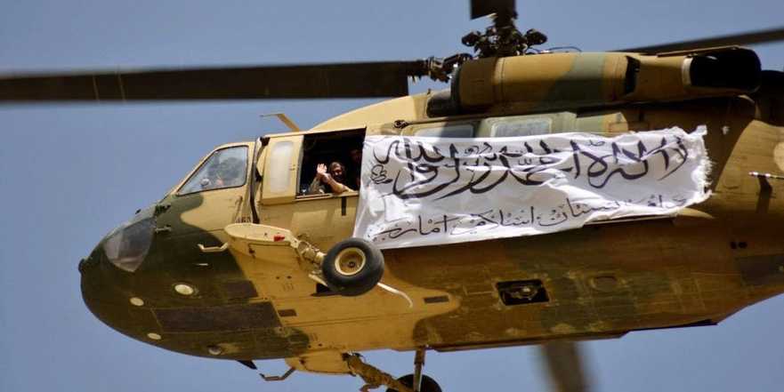 Talibani, la bordul unui elicopter cu un banner sărbătorind victoria asupra forţelor SUA