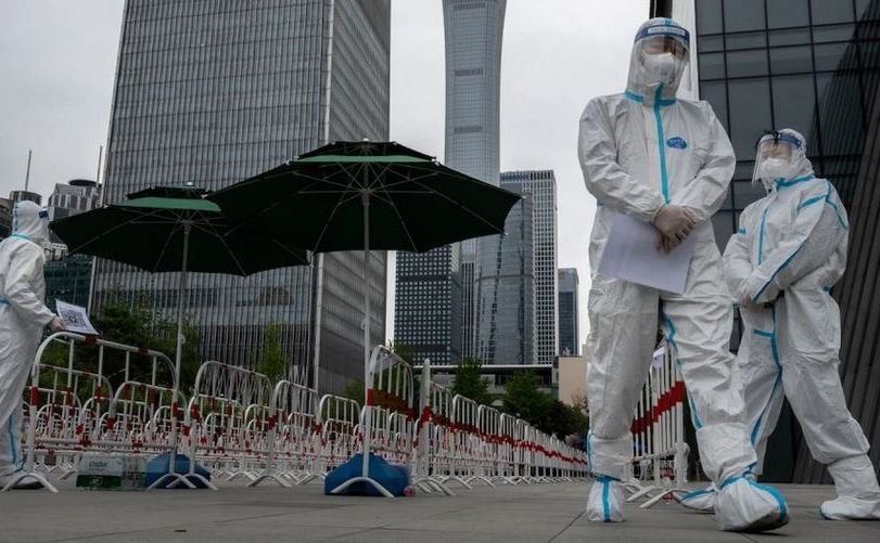 Lucrătorii din domeniul sănătăţii poartă costume de protecţie în Beijing, 27 aprilie 2022