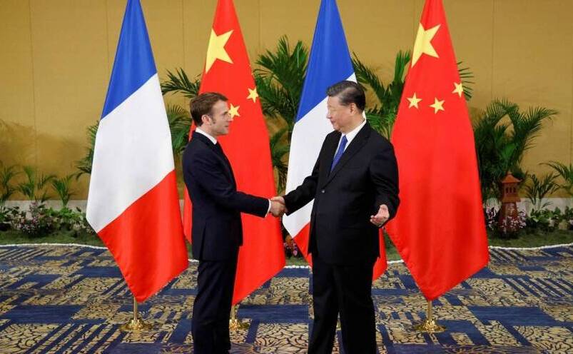 Emmanuel Macron (st) dă mâna cu Xi Jinping înainte de întâlnirea lor în Bali, 15 noiembrie 2022