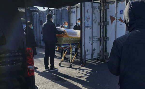 Un sicriu este încărcat dintr-un dric într-un container de depozitare la crematoriul şi casa funerară Dongjiao, una dintre cele câteva din oraş care se ocupă de cazurile COVID-19, în Beijing, China, la 18 decembrie 2022.