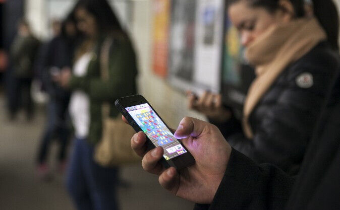 Oameni care joacă Candy Crush în metroul din New York, 1 aprilie 2014. (Samira Bouaou/Epoch Times)