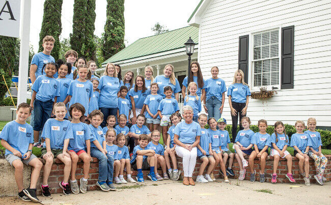 Vera Stewart cu participanţii la tabăra de vară VeryVera Cooking Summer Camp, unde aceştia învaţă cum să gătească, să pună masa, să împăturească un şerveţel, să ţină tacâmurile de argint, să prezinte o masă şi să întâmpine şi să servească oaspeţii. (Wier/Stewart)