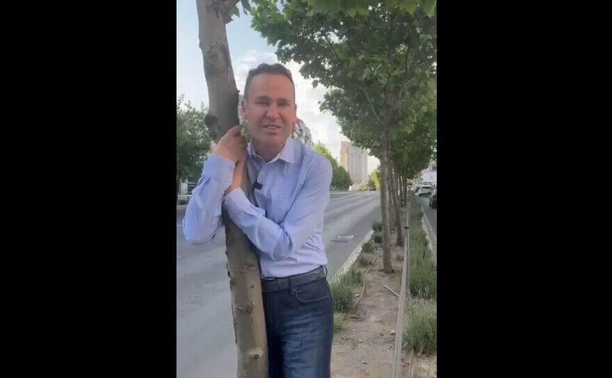 Robert Negoiţă îmbrăţişând un copac în Bucureşti