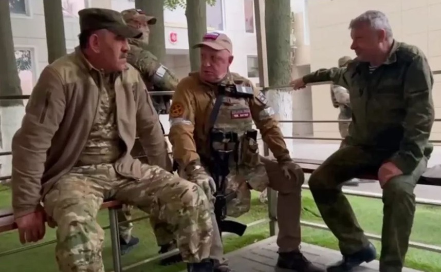 Prigojin (centru), stând pe o bancă din Rostov pe Don, glumind amical cu ministrul adjunct al apărării rus, Yunus-Bek Evkurov, şi cu adjunctul şefului serviciilor secrete militare ruse, GRU, generalul-locotenent Vladimir Alekseyev.
