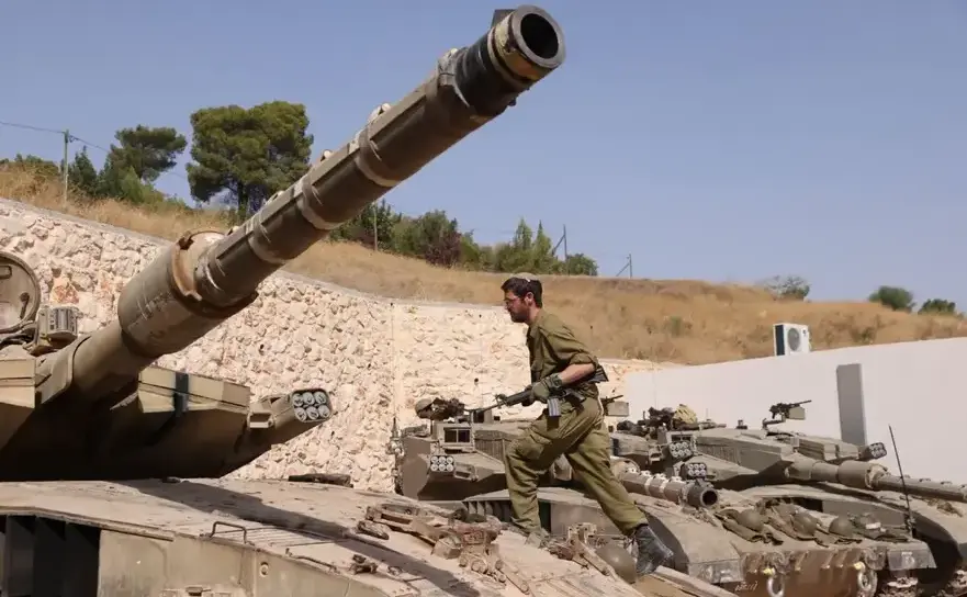 Un soldat israelian pe lângă un tanc Merkava la graniţa cu Libanul,  22 octombrie 2023.