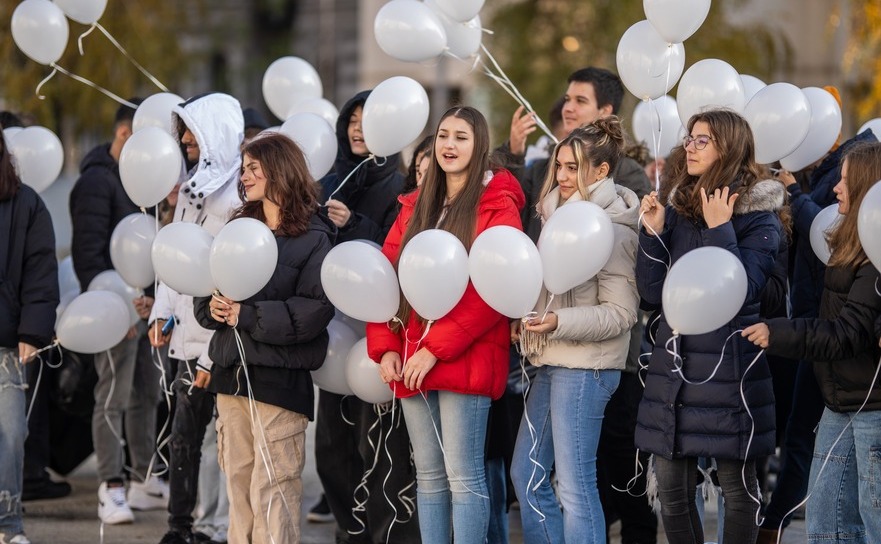 Elevi bucuresteni pregatindu-se sa elibereze baloane albe in memoria copiilor ucisti la Plataresti