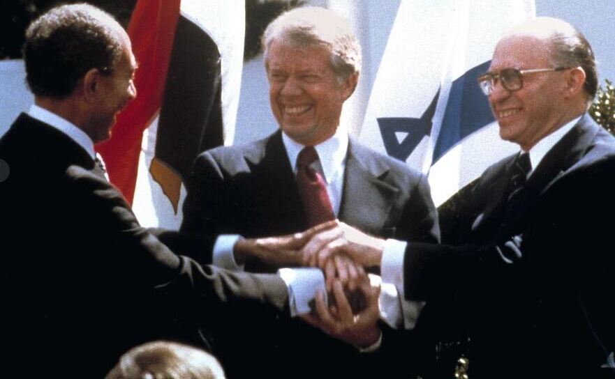 Preşedintele egiptean Anwar Sadat (st), preşedintele SUA Jimmy Carter (centru) şi premierul Israelului Menchem Begin dându-şi mâna după semnarea acordului de pace, la Casa Albă, 26 martie 1979