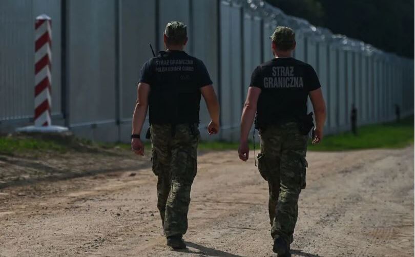 Poliţişti de frontieră polonezi lângă noul gard de la graniţa polono-bielorusă, 30 iunie 2022, în Voievodatul Podlaskie, Polonia.