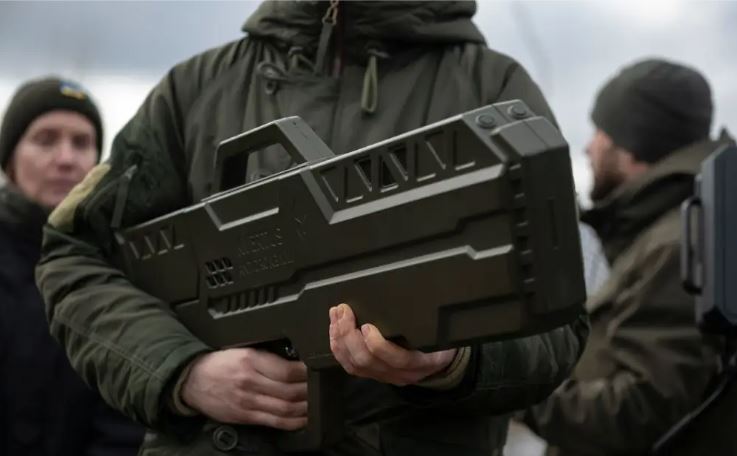 Un militar ţine în mână un sistem portabil de război electronic la un eveniment din Ucraina.