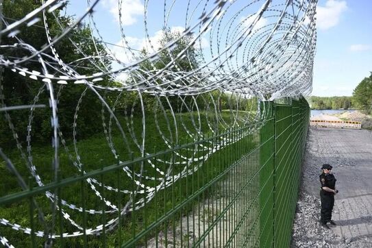 Un membru al Gărzii de frontieră finlandeze stă lângă un gard de-a lungul frontierei finlandezo-ruse în Pelkola, Imatra, Finlanda, 30 mai 2023 (Getty Images)