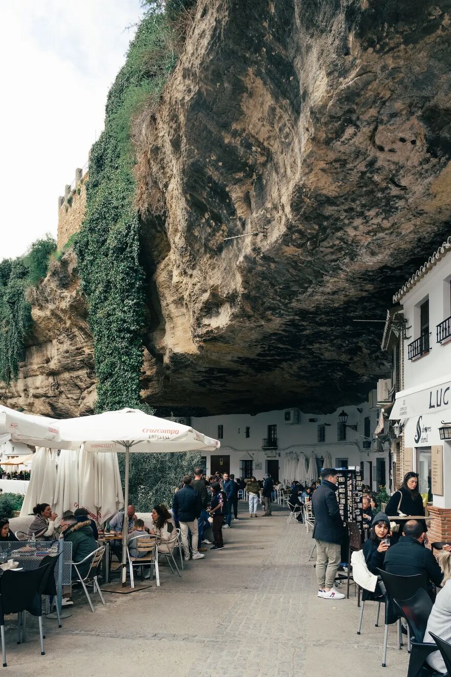 Patronii localurilor de pe Calle Cuevas del Sol se bucură de aer liber în Setenil de las Bodegas. (Atapialopez28/Shutterstock)