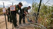 Agenţii Patrulei de Frontieră a SUA fac o deschidere prin sârma ghimpată după ce familii de imigranţi au traversat Rio Grande din Mexic în Eagle Pass, Texas, 27 septembrie 2023. (Getty Images)