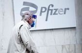 Un bărbat purtând mască de protecţie şi vizieră trece pe lângă sediul Pfizer din New York, pe 11 martie 2021 (Kena Betancur/AFP/Getty Images *)