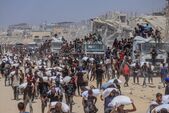 Palestinieni cărând saci cu alimente de bază în Gaza, pe fondul unei lipse acute de hrană, 2025 (Ramez Habboub / Future Publishing via Getty Images)